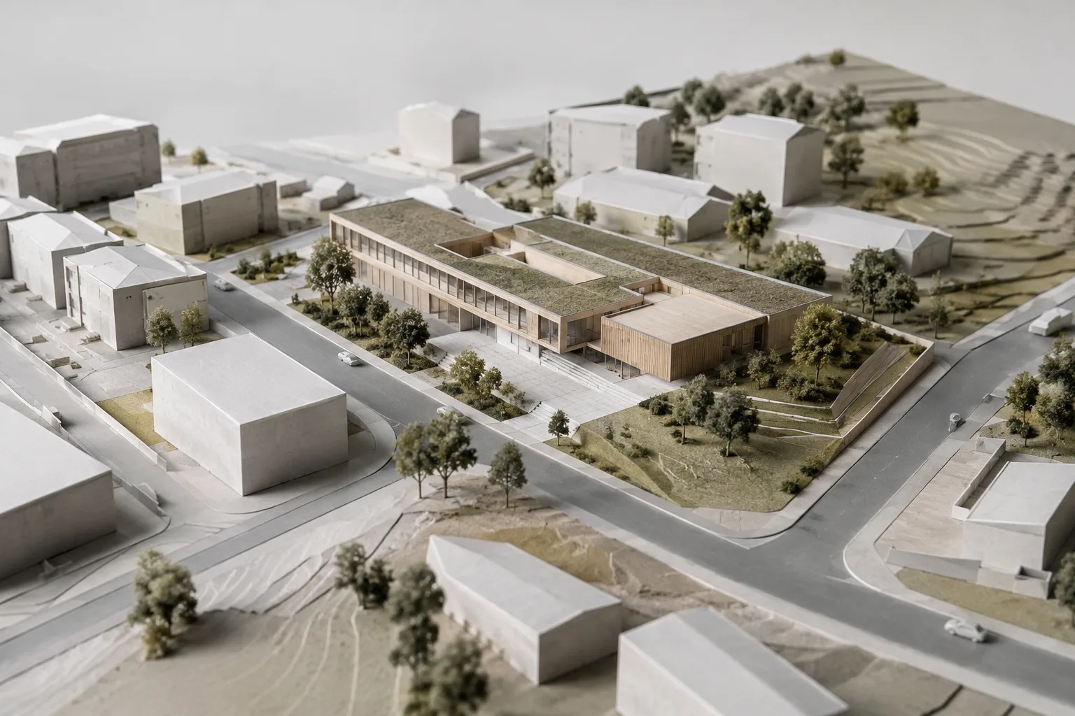 A contemporary architectural design shown alongside an urban context and terrain model